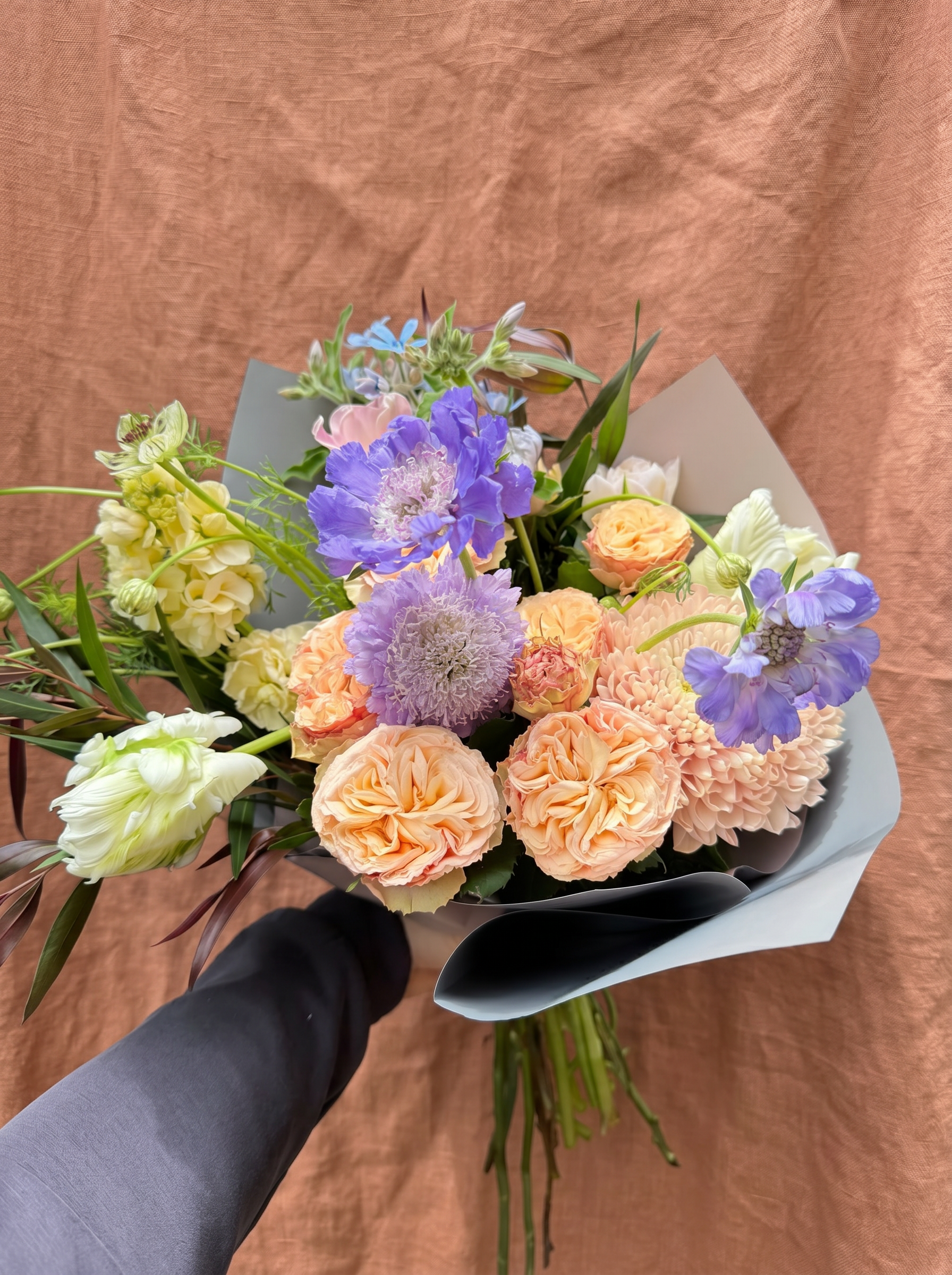 Peach garden roses, lavender scabiosa and butter yellow stock hand-tied bouquet